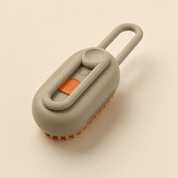 Steam brush three-quarter view showing the loop handle and button